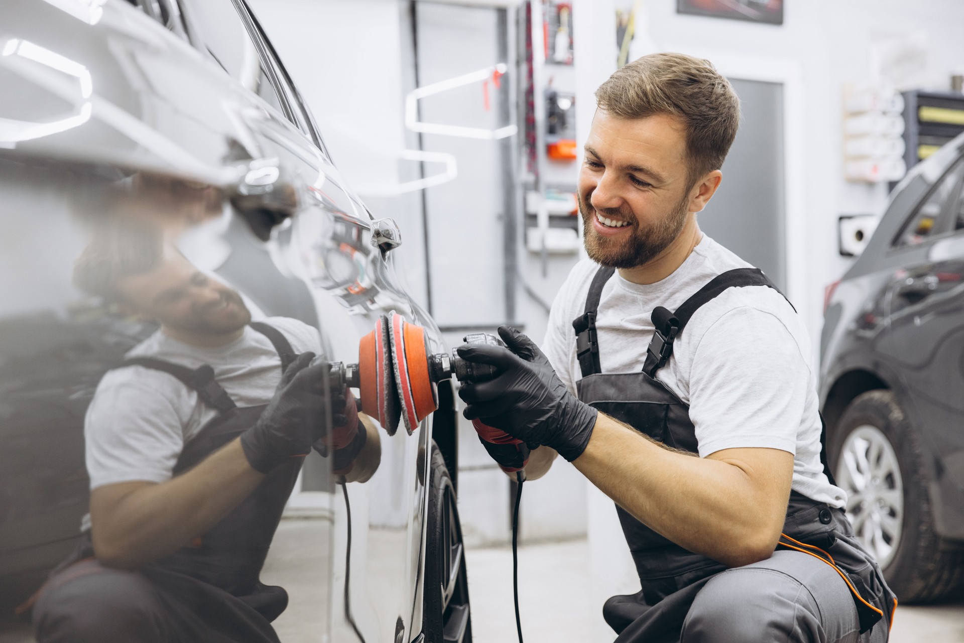 Professional Car Detailing with an Auto Polisher in a Garage Setting
